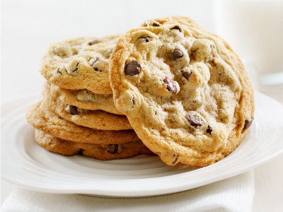 Six finished cookies stacked on top of each other sitting on a white round plate.